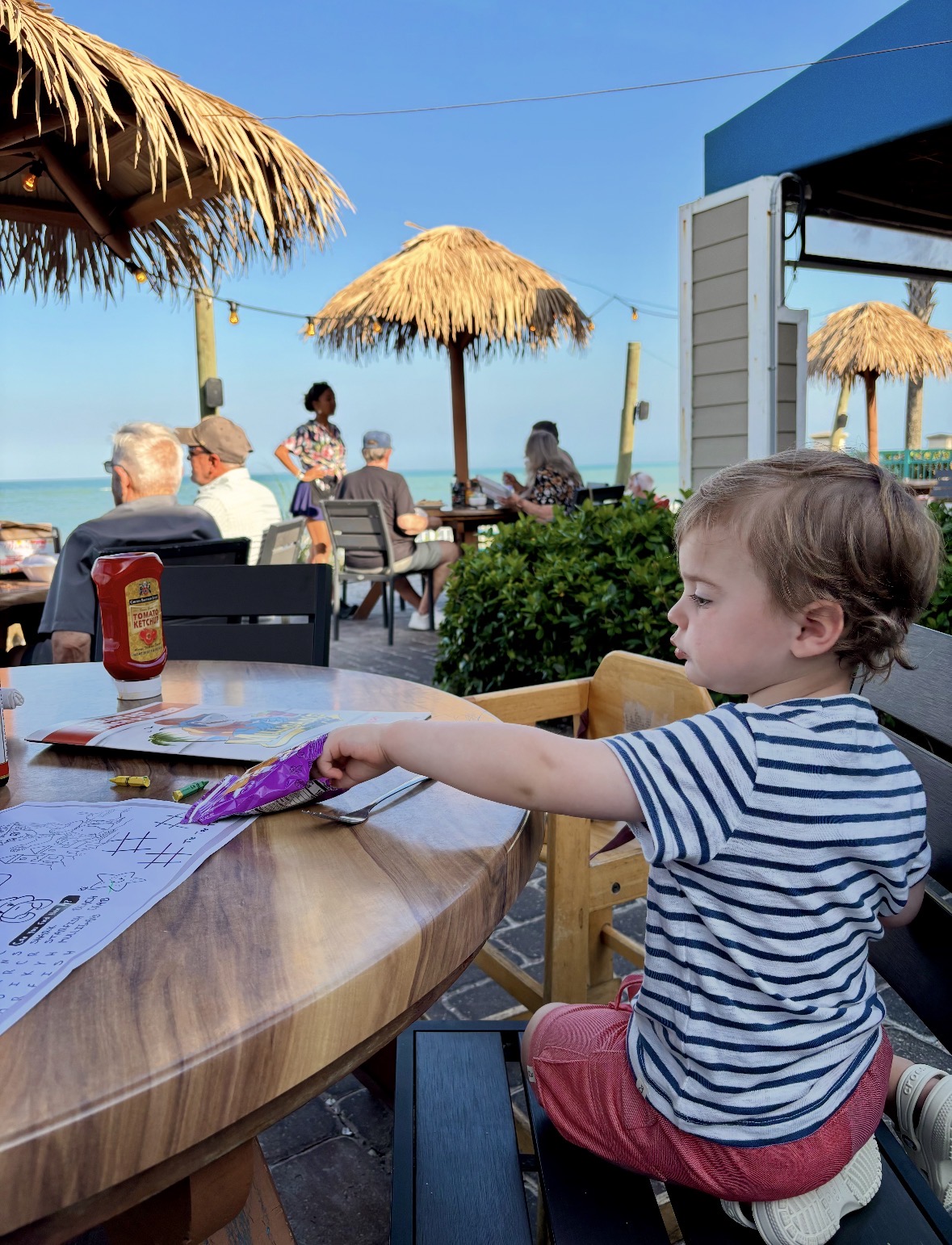 Toddler coloring at Mulligan's tiki-style oceanfront restaurant in Vero Beach