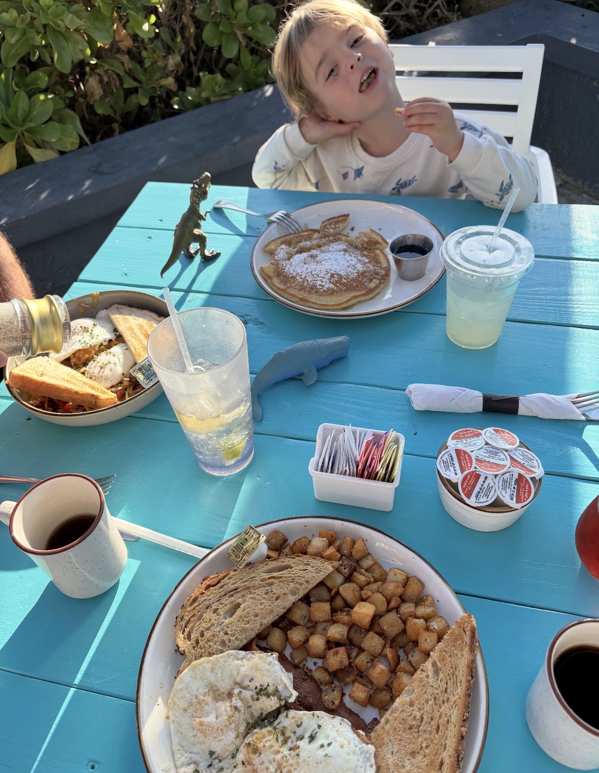 Family breakfast at Seaside Grill with bunny pancakes on a blue patio table